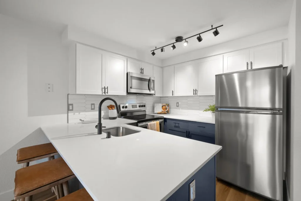 kitchen with white countertops and cabinets, stainless steel appliances, and bar height seating