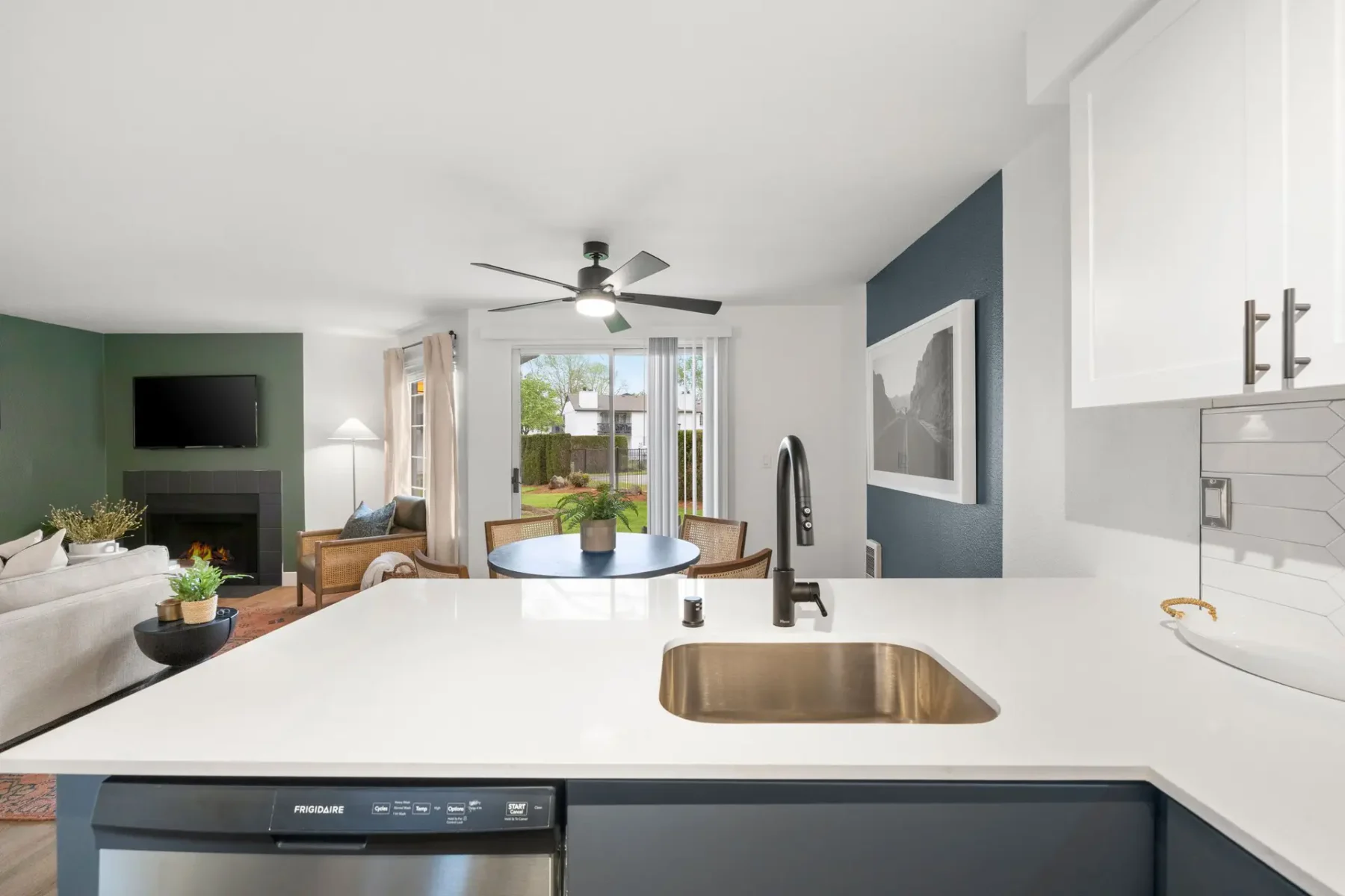 kitchen looking into dining area, with large glass doors leading to outdoor green space